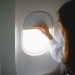 asian woman sitting seat airplane looking out window