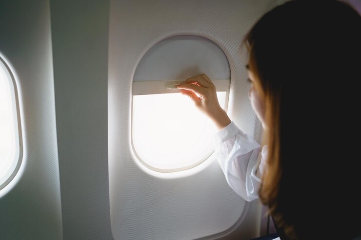 asian woman sitting seat airplane looking out window